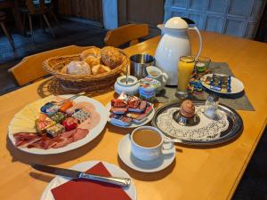a table topped with plates of food and cups of coffee at Gasthof Adler in Zusmarshausen