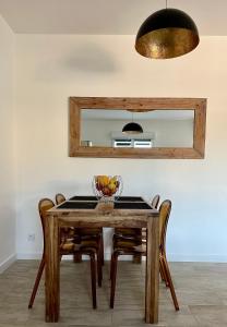 a dining room table with chairs and a mirror at Residence Casa Di Paoli in Porto-Vecchio