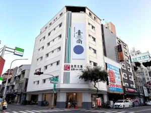 un edificio blanco con un cartel en el costado en 信然文旅-首學 寵物友善預訂前務必事先詢問 en Tainan