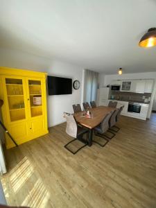 a living room with a table and a yellow cabinet at Ferienhaus 14 "Gut Tossens" in Tossenserdeich