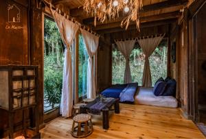 a bedroom with a bed in a room with windows at La Maison House & Bungalow in Sa Pa