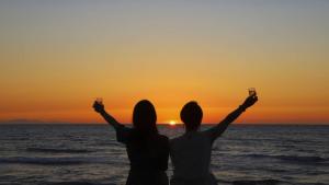 two people holding up cell phones in front of the ocean at Miyuki Hamabaru Resort in Onna