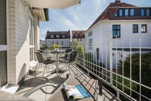 a patio with a table and chairs on a balcony at Villa Ney in Norderney