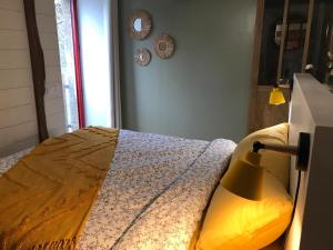 ein Schlafzimmer mit einem Bett mit einer Lampe in der Unterkunft Maison à la campagne Les Oliviers in La Bruffière