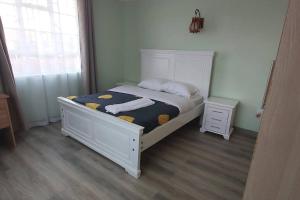 a bedroom with a white bed and a window at Modern &homely guest suite w/free parking in Karen in Nairobi