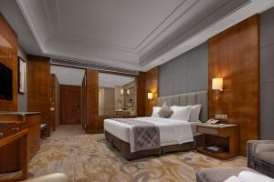 Säng eller sängar i ett rum på WorldHotel Grand Jiaxing Hunan