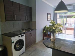 a kitchen with a washing machine on a counter at Tarrentoela selfcatering guesthoese in Kathu