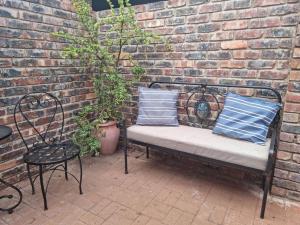 a bench sitting in front of a brick wall at Tarrentoela selfcatering guesthoese in Kathu