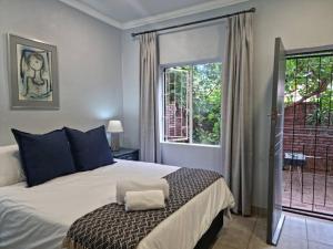 a bedroom with a bed and a large window at Tarrentoela selfcatering guesthoese in Kathu