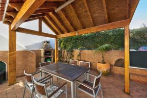 a patio with a wooden table and chairs on a deck at Lagos Terrace Villa in Lagos