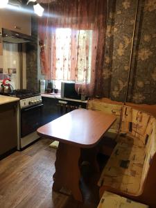 a kitchen with a wooden table in the middle of a room at Затишна однокімнатна квартира 5 хв від Південного вокзалу in Kharkiv