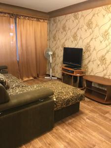 a living room with a couch and a flat screen tv at Затишна однокімнатна квартира 5 хв від Південного вокзалу in Kharkiv