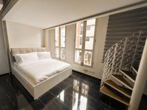 Un pequeño dormitorio con una cama y una escalera en D'Nova Hotel Bugis en Singapur