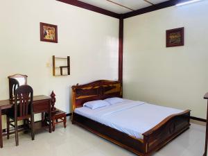 a bedroom with a bed and a desk and a table at Khách sạn Sao Mai in Ben Tre