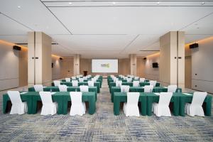 a conference room with green tables and white chairs at Home2 Suites By Hilton Wuhan Xudong in Wuhan