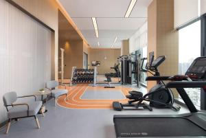 Home2 Suites By Hilton Wuhan Xudong في ووهان: صالة ألعاب رياضية مع أجهزةالجري والتمرين في مبنى
