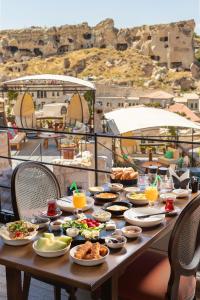 a table with plates of food on a balcony at Elysion Cave Suites in Urgup