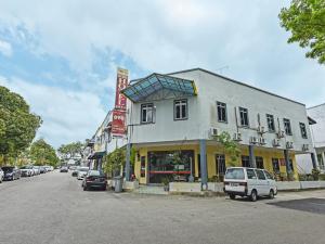 a building on the side of a street with cars parked at Super OYO 44036 Hotel De Perdana Hill in Batu Pahat