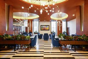 ホーチミン・シティにあるMuong Thanh Grand Saigon Centre Hotelの建物内の椅子とテーブルのあるロビー
