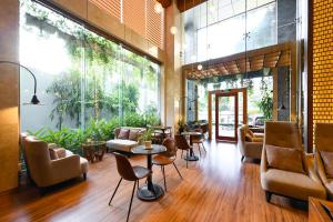 a lobby with chairs and tables and a large window at Muong Thanh Grand Saigon Centre Hotel in Ho Chi Minh City