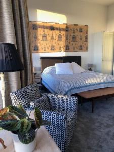 ein Schlafzimmer mit einem Bett, einem Stuhl und einem Sofa in der Unterkunft Zen House By The Sea In Margate in Kent