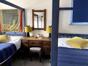 1 Schlafzimmer mit 2 Etagenbetten und einem Schreibtisch mit einem Spiegel in der Unterkunft Zen House By The Sea In Margate in Kent