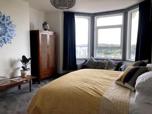 a bedroom with a large bed and a large window at Zen House By The Sea In Margate in Kent