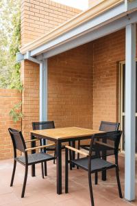a wooden table and chairs on a patio at Middleton Beach by the BnB Collection in Albany