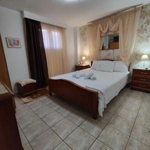 a bedroom with a large bed with white sheets at Giorgos-Vera in Kavála