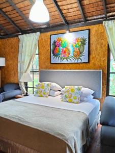 1 dormitorio con 1 cama grande y 2 sillas azules en Resort D Rumah Bonda River View Kuala Kangsar en Kampong Senawar