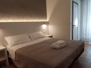 una camera da letto con un letto e due asciugamani di Albergo Conca d'Oro a Rimini