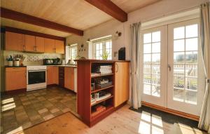 SønderhoにあるBeautiful Home In Fan With Saunaのキッチン(木製キャビネット付)、大きな窓が備わります。