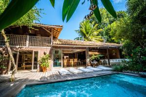 a villa with a swimming pool and a house at Casa Angatu in Trancoso