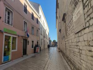 una persona caminando por una calle en un callejón en Apartment Essenza, en Zadar