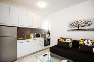 Una sala de estar con un sofá y una cocina. en Apartment Essenza, en Zadar