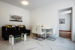 Una sala de estar con un sofá negro y una mesa. en Apartment Essenza, en Zadar 11 fotos más