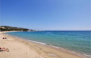 a beach with people laying on the sand and the water at Awesome Apartment In Sainte-Maxime in Sainte-Maxime