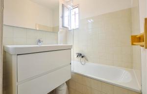 a white bathroom with a sink and a bath tub at Awesome Apartment In Sainte-Maxime in Sainte-Maxime