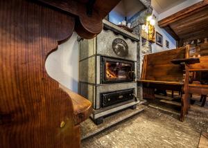 a woodburning stove in a room with a piano at Albergo Meublè Vecchio Scarpone in Baceno