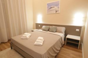 a bedroom with a bed with two towels on it at Etna Vibes Home in Catania