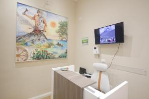 Cette chambre dispose d'une télévision et d'une peinture murale. dans l'établissement Etna Vibes Home, à Catane