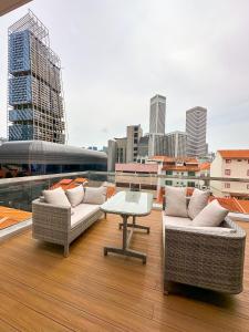einen Balkon mit 2 Sofas und einem Tisch auf einem Gebäude in der Unterkunft D'Nova Hotel Bugis in Singapur