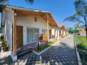 une maison avec une terrasse couverte et une passerelle dans l'établissement VITS Daman Devka Beach, à Daman