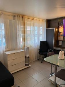 um escritório com uma secretária, uma mesa e uma janela em Résidence Zola em Villeurbanne