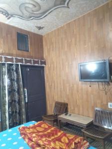 1 dormitorio con TV en la pared y 1 cama en HOTEL JOGI GUEST HOUSE, en Amritsar