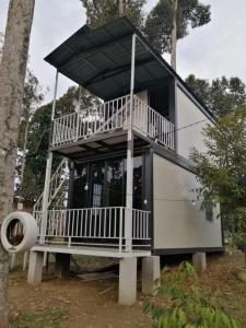 a tree house with a large balcony on display at Resort D Rumah Bonda River View Kuala Kangsar in Kampong Senawar