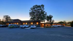 a building with cars parked in a parking lot at New Crossing Place Motel in Seymour