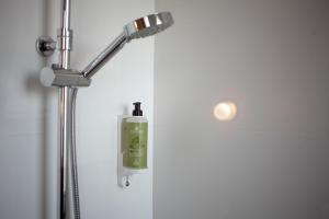 une douche avec un distributeur de savon dans une salle de bain dans l'établissement Hotel Saint Louis, à Brest 51 autres photos