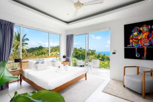 a bedroom with a bed and a view of the ocean at Villa Melo in Chaweng Noi Beach