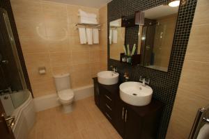 a bathroom with two sinks and a toilet and a mirror at The Plough Inn in Pocklington +11 photos
